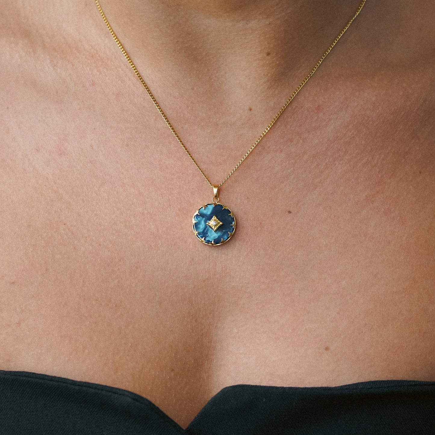 Dames ketting – Ronde hanger met blauwe steen en stervormige rand