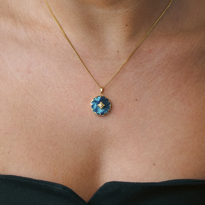 Dames ketting – Ronde hanger met blauwe steen en stervormige rand