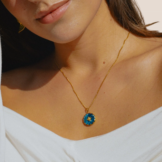 Dames ketting – Ronde hanger met blauwe steen en stervormige rand